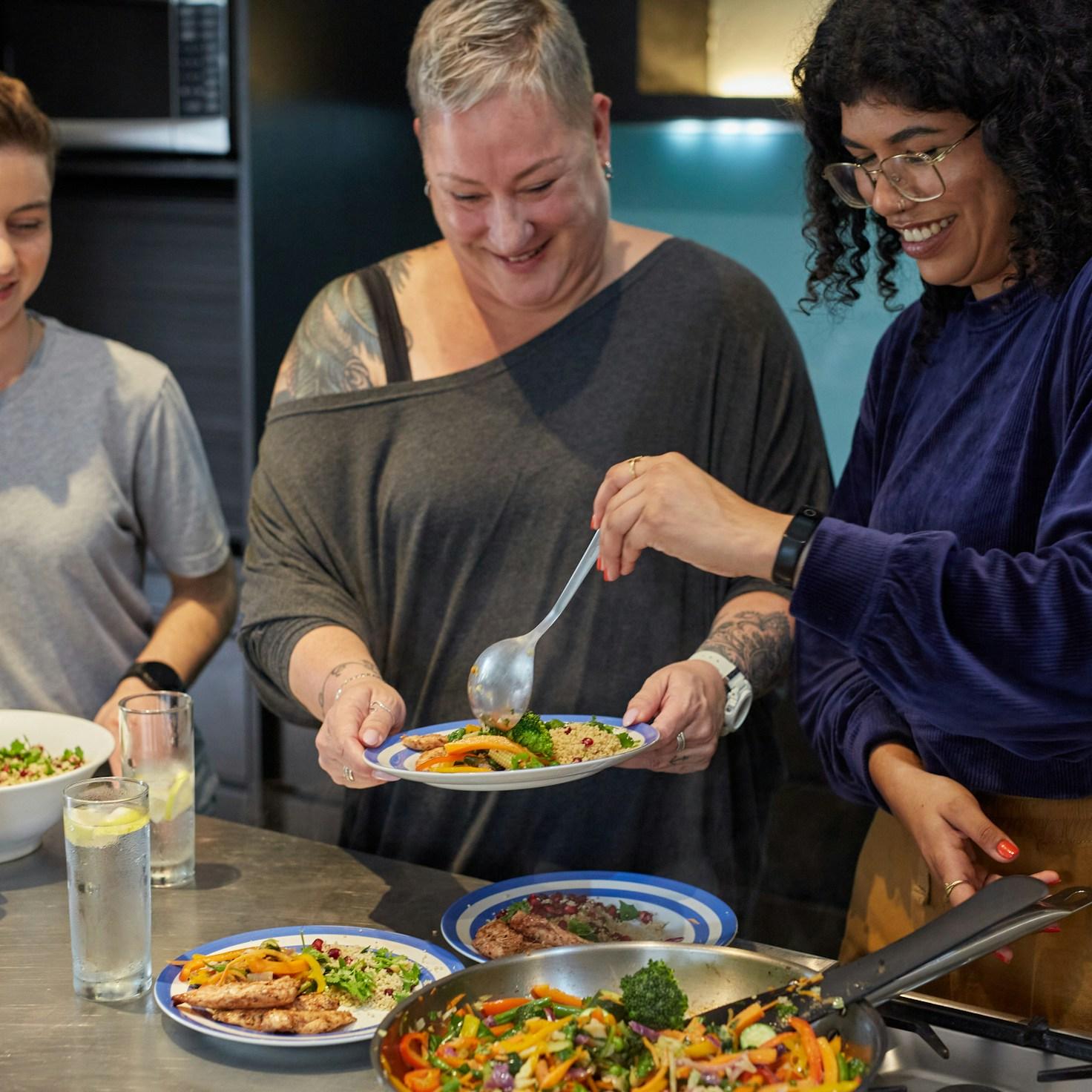 Diverse group of community members sharing a meal together, showcasing the social bonds formed through collaborative cooking